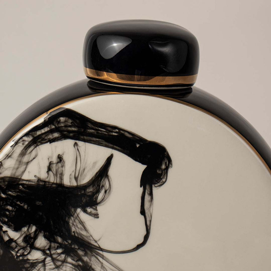 Closeup view of round ceramic vase in black and white tones highlighting detailed abstract ink pattern for table styling.