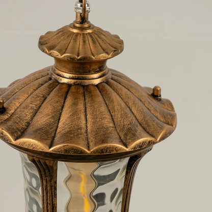 Closeup of gold metal outdoor lantern showing textured glass and elegant crafted top perfect for vintage style patio balcony and garden Decor.