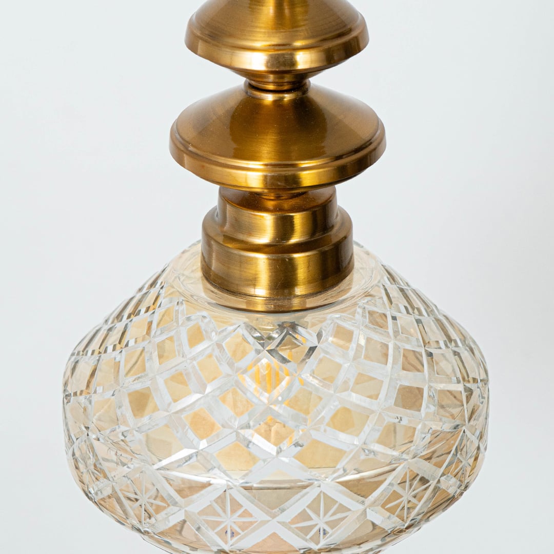 Detailed view of patterned glass and gold metal pendant light showcasing artistic craftsmanship.