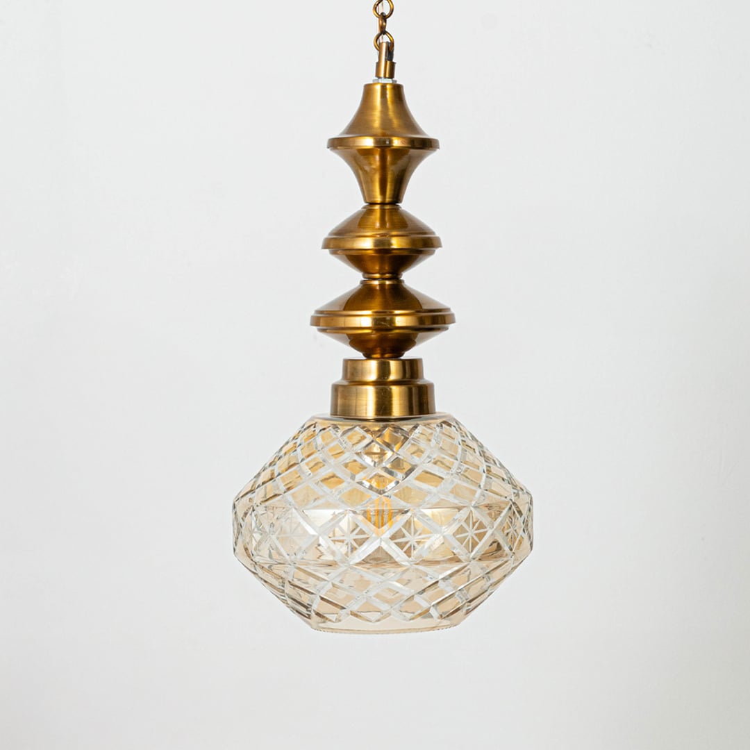 Faceted patterned glass and gold metal pendant light for classic home decor and ambient lighting.