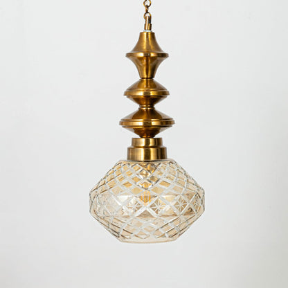 Faceted patterned glass and gold metal pendant light for classic home decor and ambient lighting.