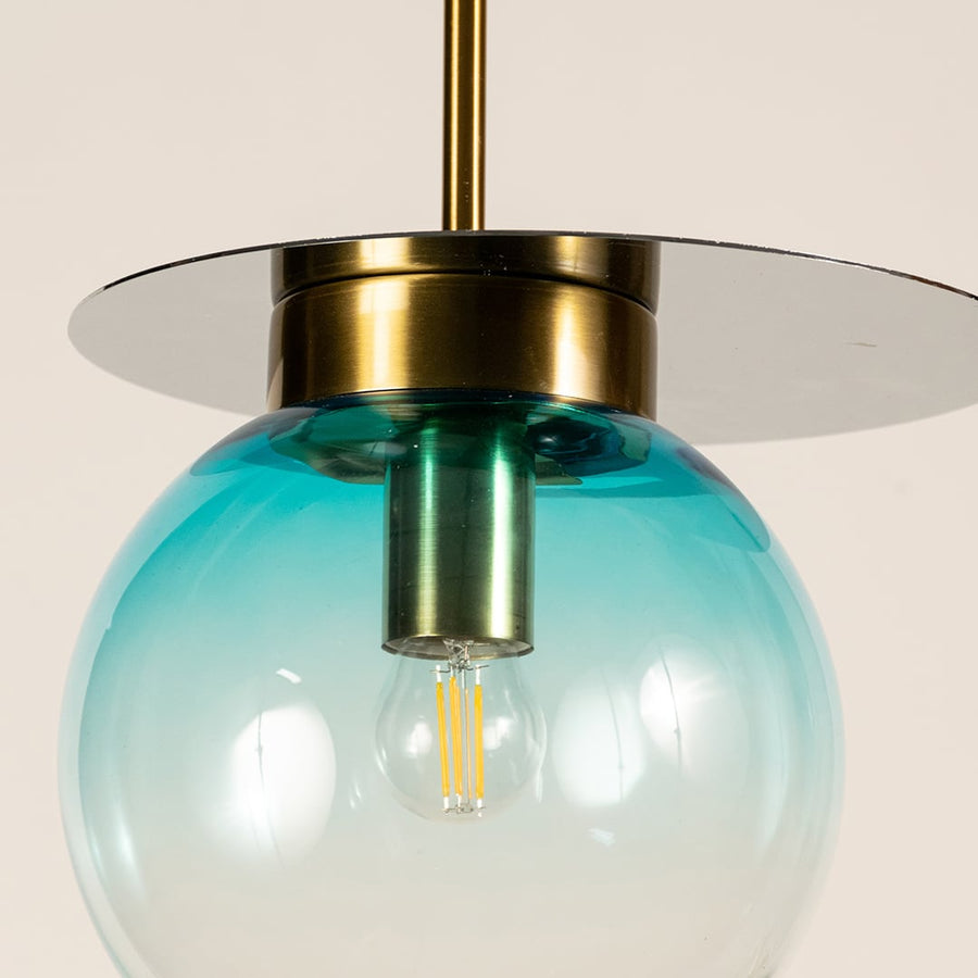 Close view of blue and transparent glass pendant light showing smooth gradient finish polished gold accent and fine modern detailing.