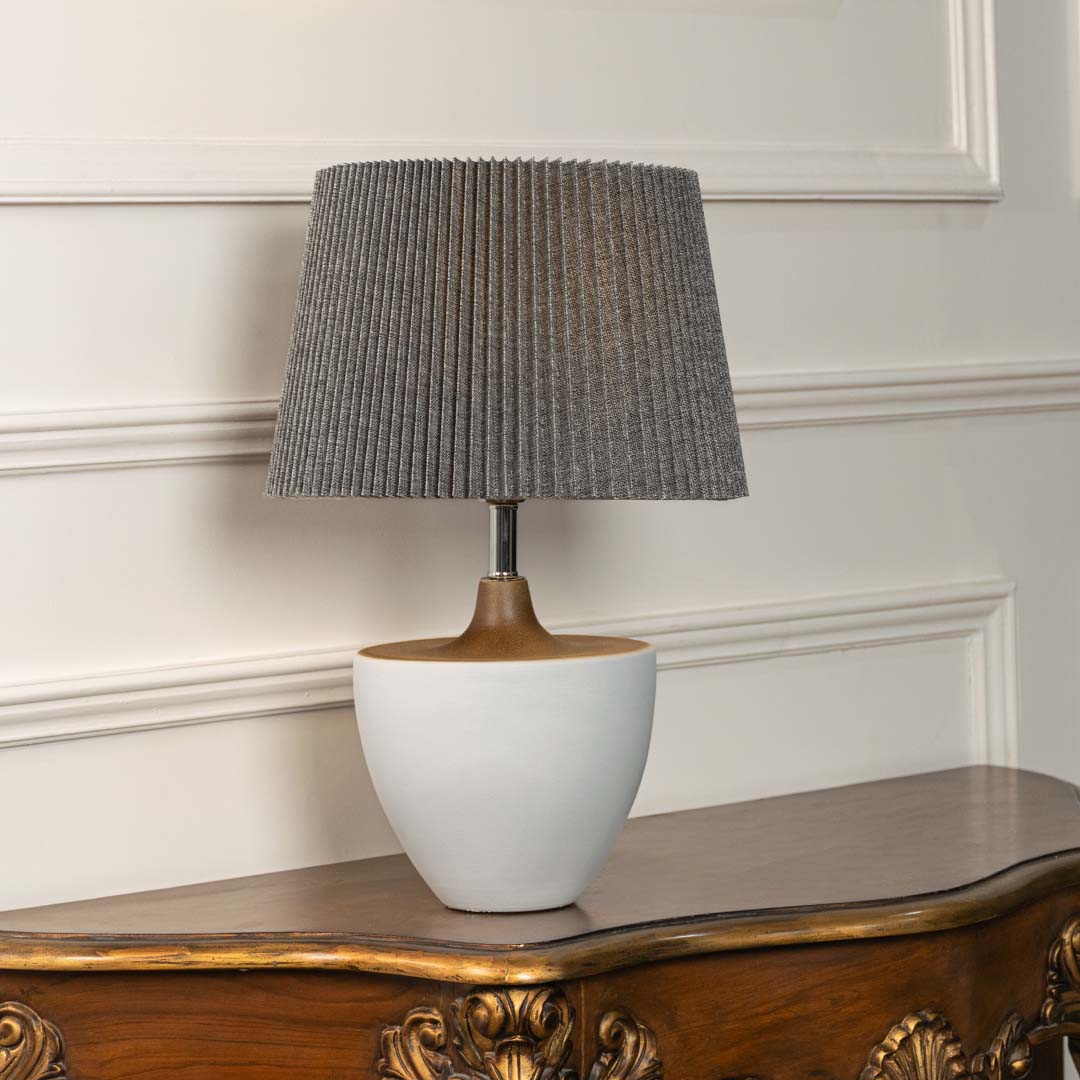 Grey ceramic table lamp with pleated fabric shade and bowl shaped base designed for sophisticated modern table lighting.