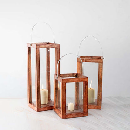 Decorative copper metal lantern set with clear glass panels for elegant indoor tabletop decor styling.
