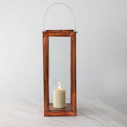 Handcrafted wooden lantern with glass panels and a silver handle displayed on white background with candlelight inside highlighting the natural wood grain.