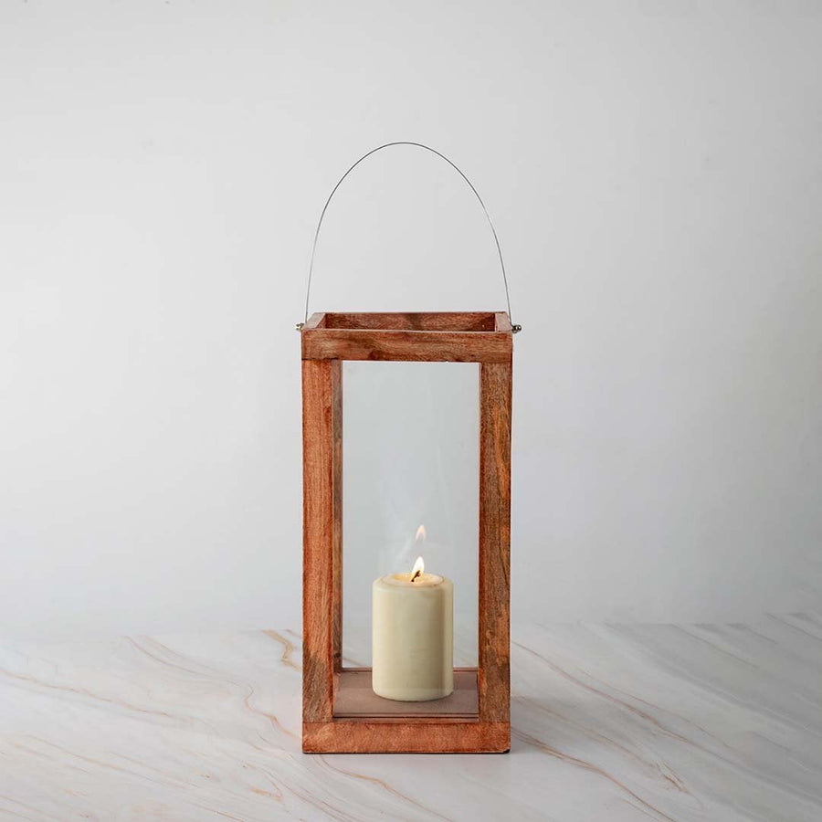 Wooden lantern illuminated with candlelight against a clean white background showcasing its minimalist design.