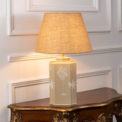 Warli Dandak beige table lamp on white background with light on displaying tribal motif soft glow and earthy interior decor feel.