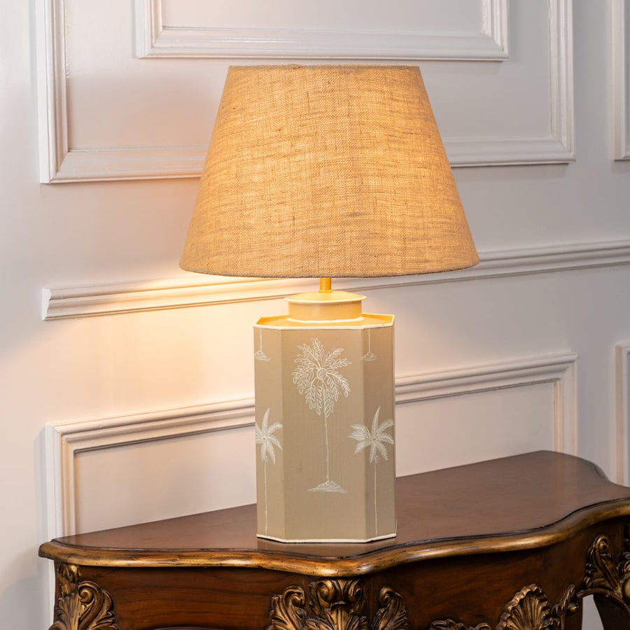 Warli Dandak beige table lamp on white background with light on displaying tribal motif soft glow and earthy interior decor feel.