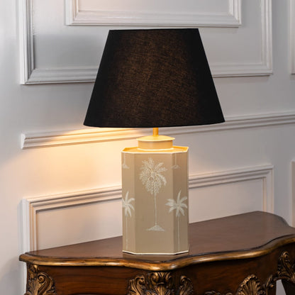 Table lamp on white background showcasing soft neutral ceramic base with subtle floral detailing paired with black fabric shade.
