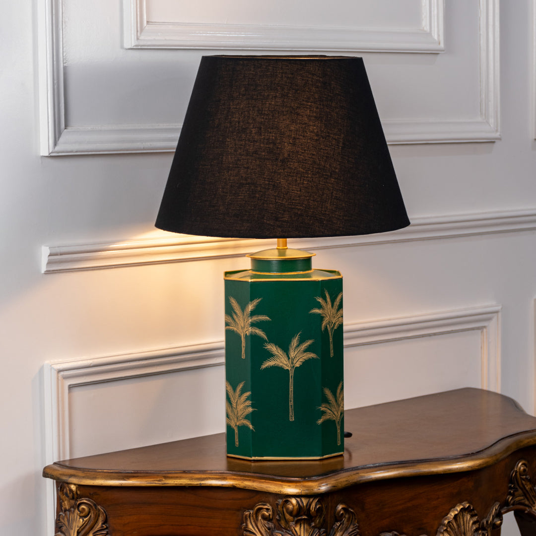 Green ceramic table lamp with gold palm pattern and fabric shade for bedside or living room decor placement white background.