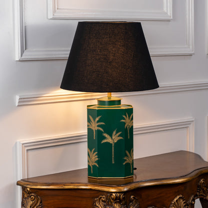 Green ceramic table lamp with gold palm pattern and fabric shade for bedside or living room decor placement white background.