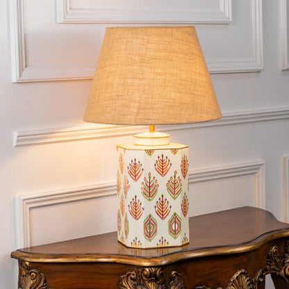 Warli Shankha table lamp illuminated on white background featuring shell inspired motif warm glow and cultural interior decor accent.