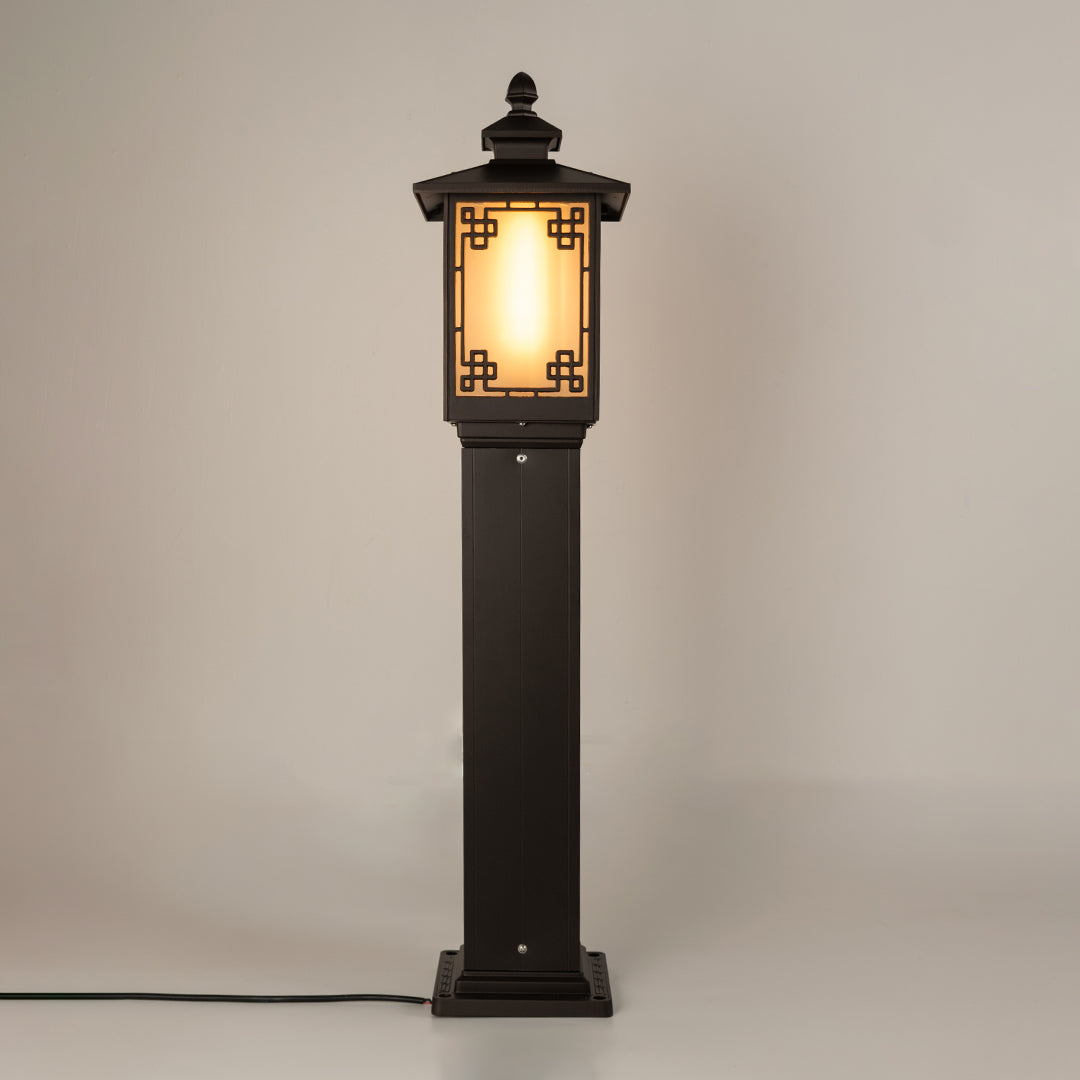 Vintage black outdoor gate light with warm glowing panels for elegant exterior decor use.