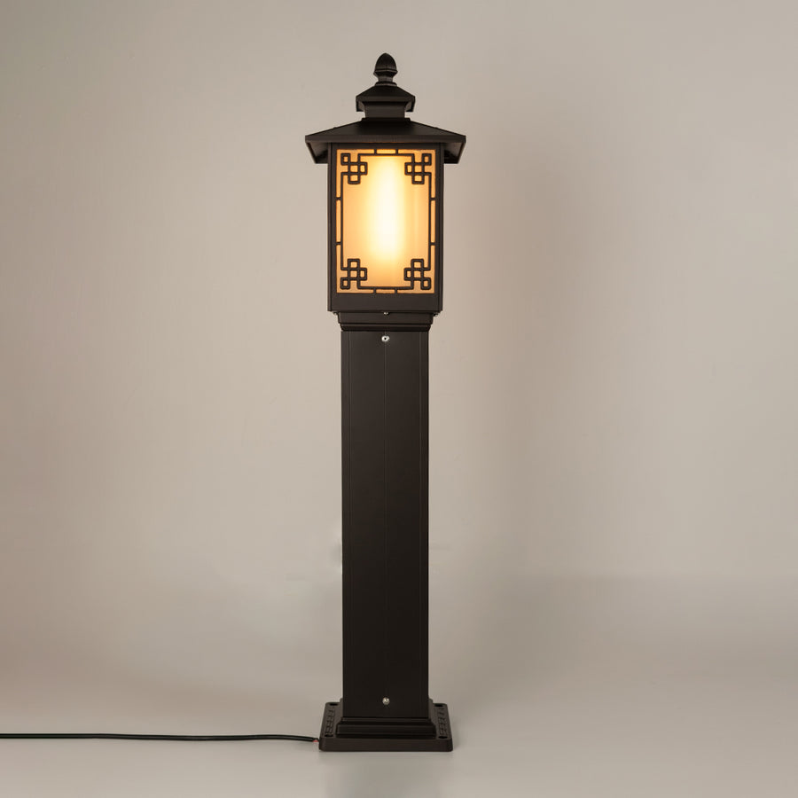 Vintage black outdoor gate light with warm glowing panels for elegant exterior decor use.