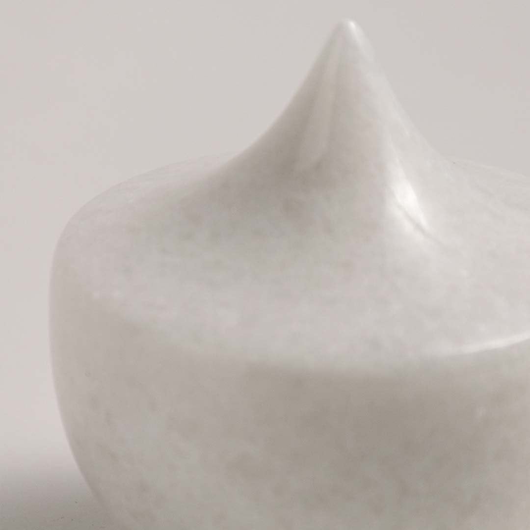 Detailed closeup of a white ceramic decor piece featuring a unique pointed design with smooth glossy surface texture.