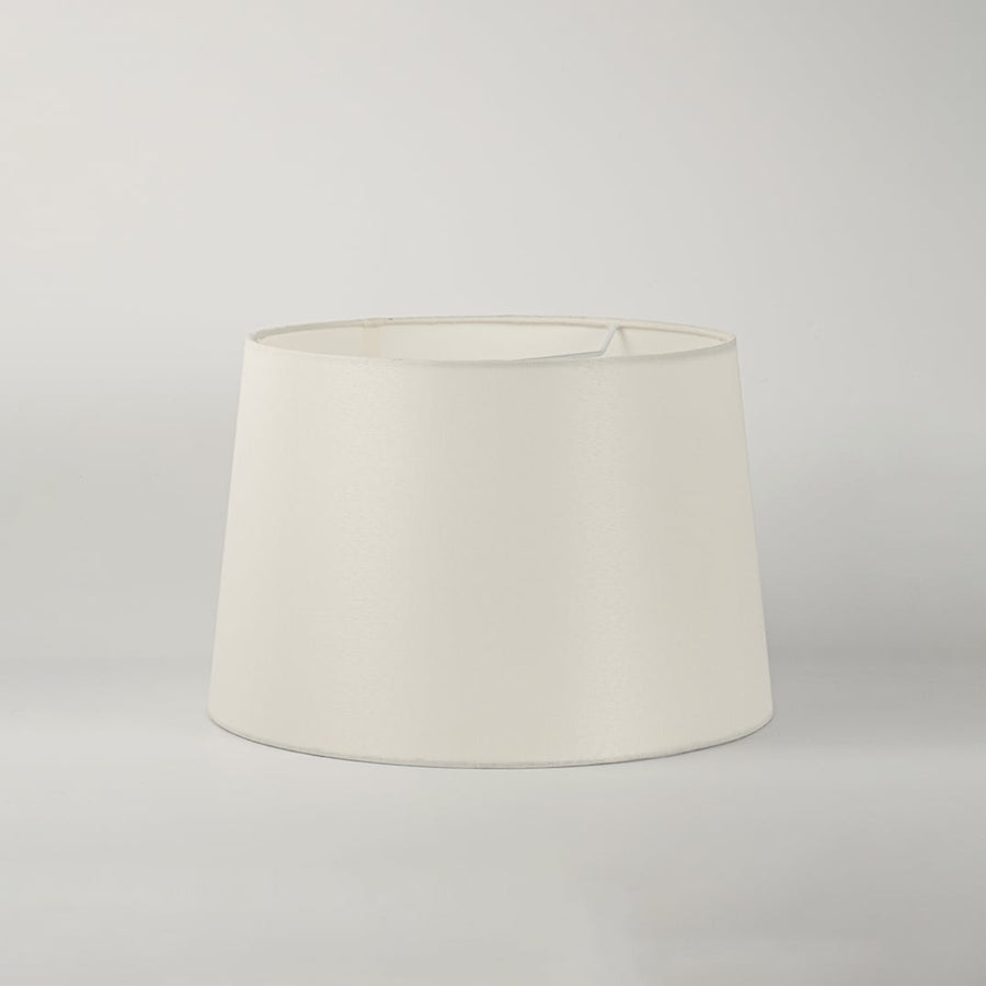 White round tapered lamp shade on plain background shown in close up view for elegant minimal lighting décor.