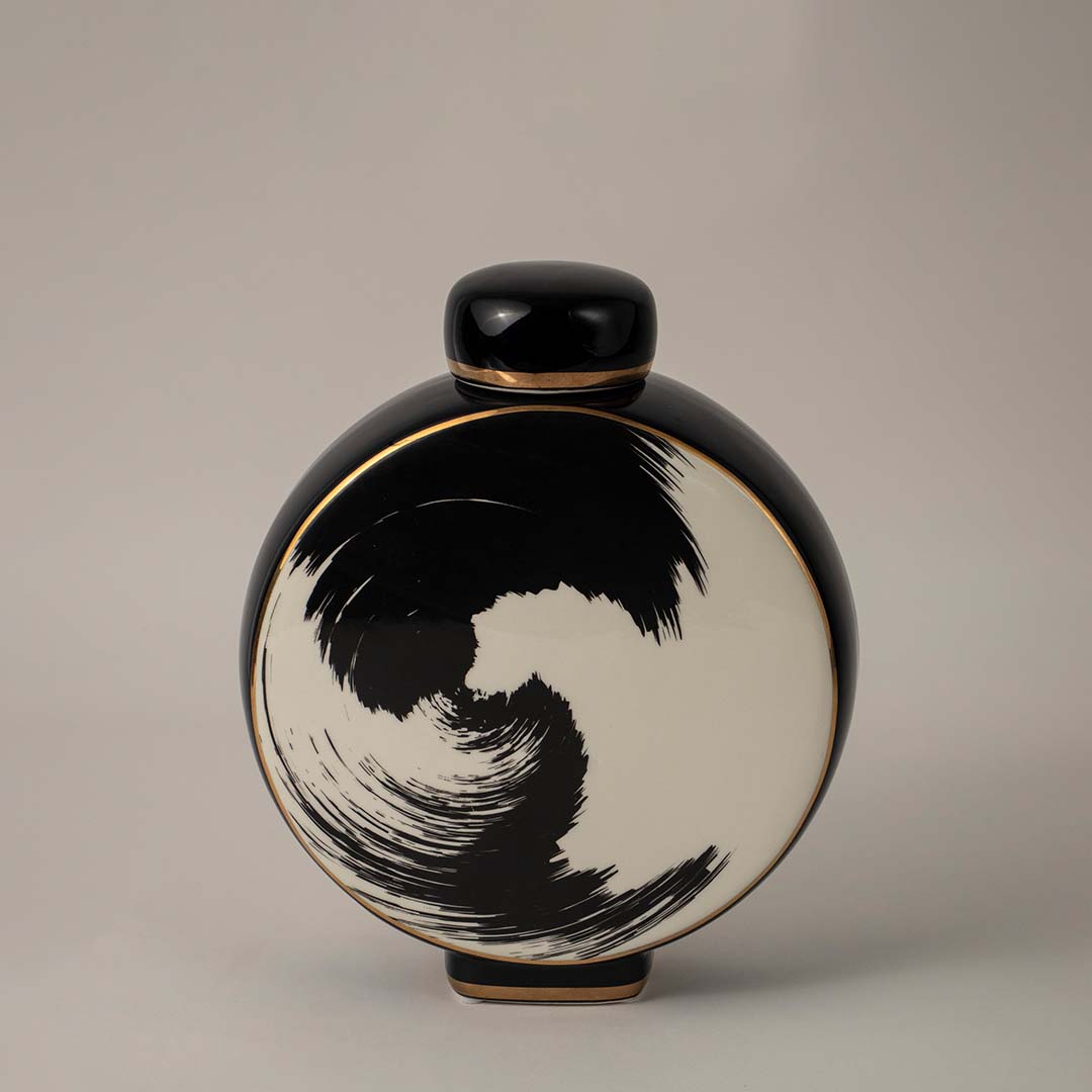 Elegant round black ceramic vase with abstract brush swirl artwork captured on white background for modern decor.