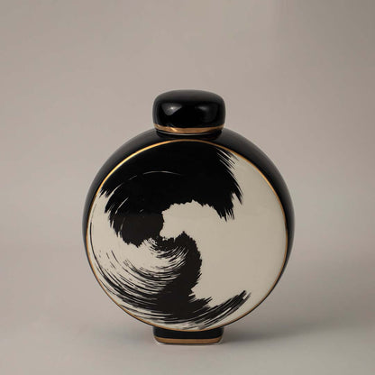 Contemporary black and beige ceramic vase with swirl art design placed on white background perfect for living room decor.