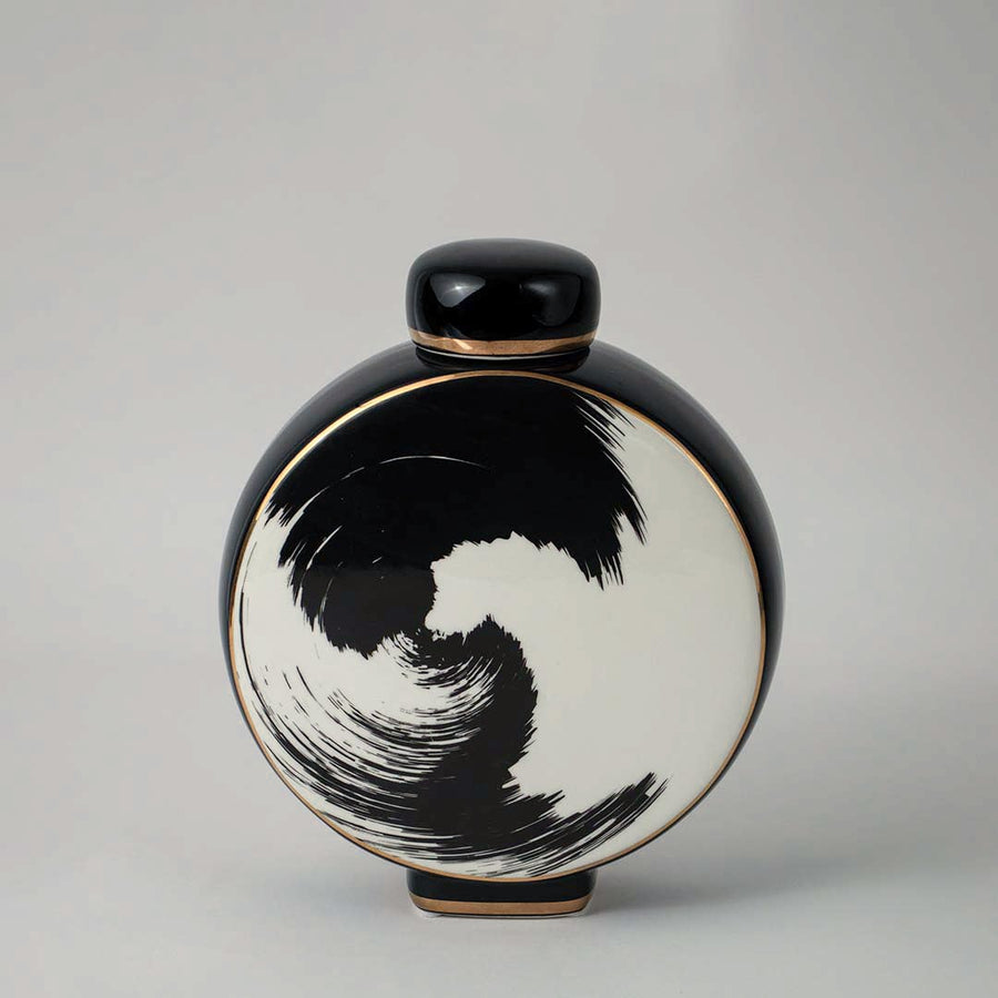 Round ceramic vase in black and beige tones with artistic swirl pattern displayed on white background for interior styling.