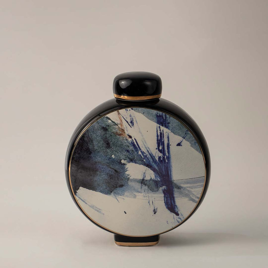 Modern black ceramic vase with blue abstract brushstroke design placed on white background for contemporary home styling.