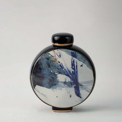 Elegant round ceramic vase in black with artistic blue and white pattern displayed on white background for interior decor.