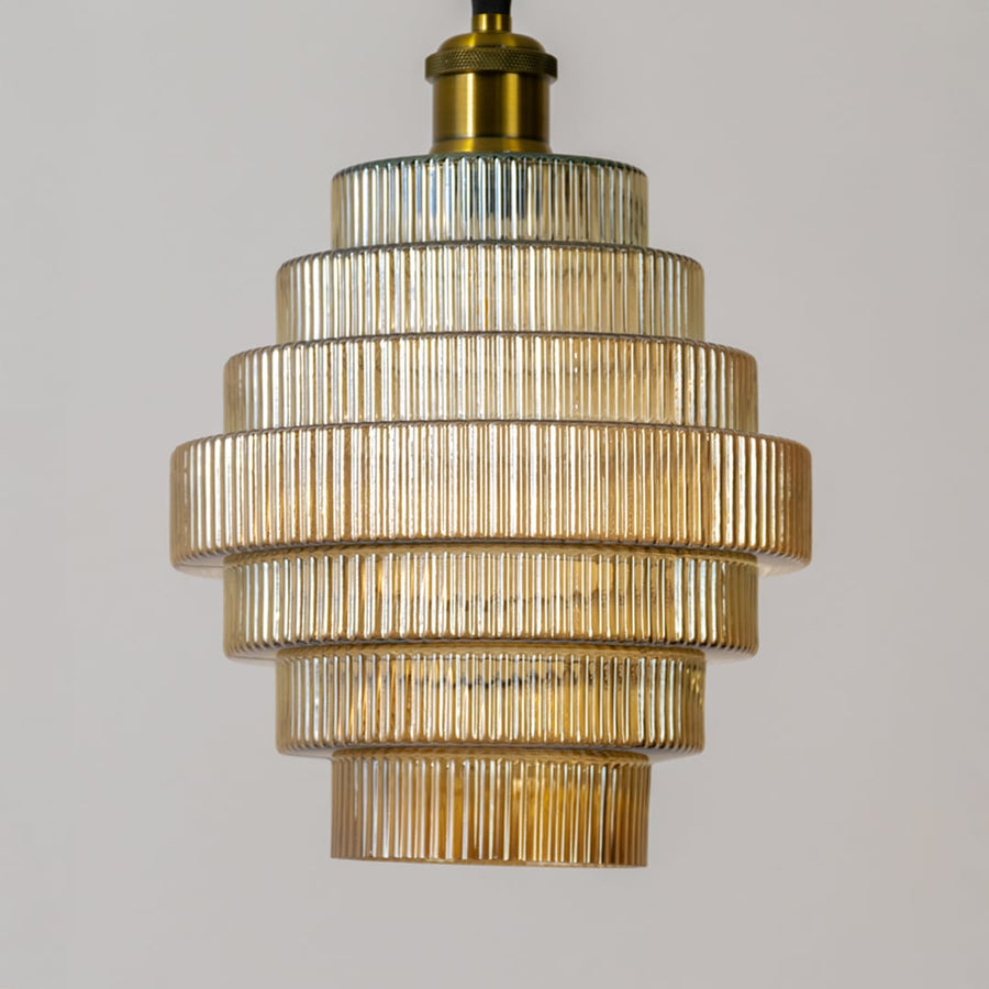 Gold metal pendant light closeup showcasing layered glass detailing and premium craftsmanship.