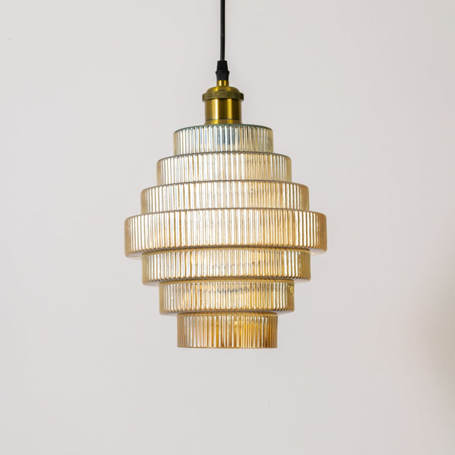 Gold metal pendant light with layered clear glass shades illuminated to highlight modern design.