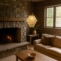 Layered glass pendant light creating warm ambient lighting in a cozy living room interior.