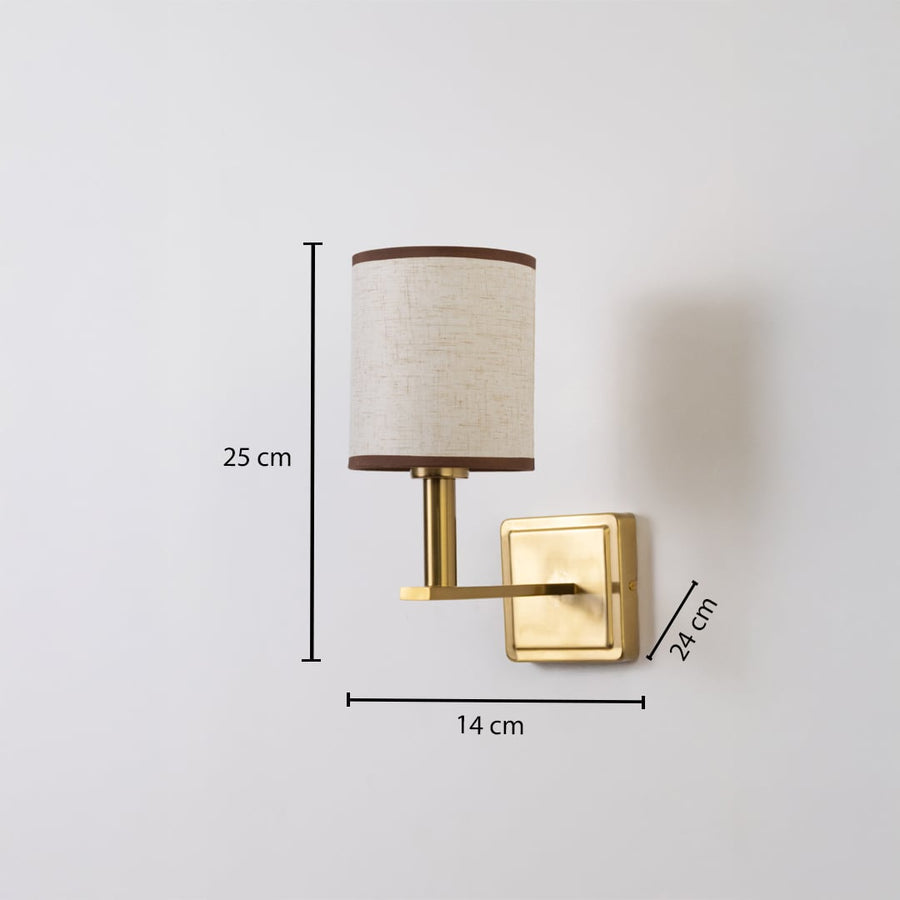 Gold wall sconce with beige drum shade shown with 25 cm height 14 cm width and 24 cm depth for accurate sizing.