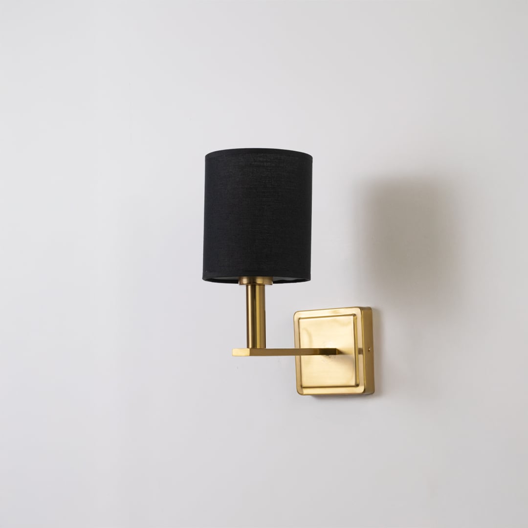 Gold wall sconce with black drum shade shown switched off on a clean white background for minimal wall decor.