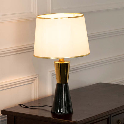 Black ceramic table lamp with fabric shade and gold accents creating sophisticated modern ambient lighting for interiors.