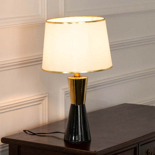 Black ceramic table lamp with fabric shade and gold accents creating sophisticated modern ambient lighting for interiors.