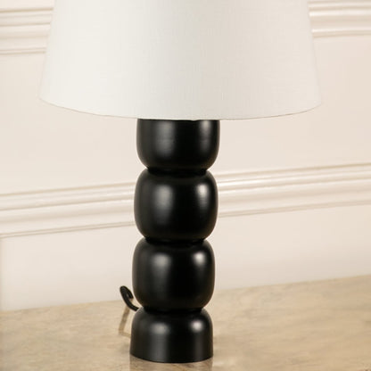 Black turned wood table lamp base with white fabric shade showcasing timeless craftsmanship and elegant design appeal.