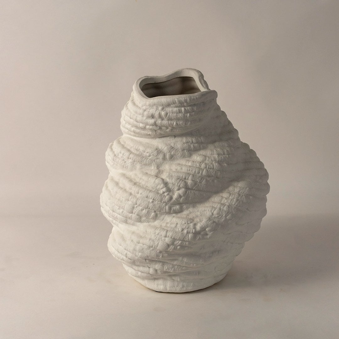 Side angle view of white ceramic sculptural vase with textured body and artistic curves perfect for unique contemporary decor.