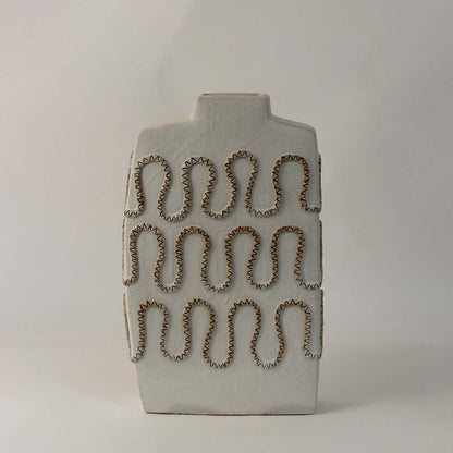 Tall white ceramic vase with artistic zigzag carved design styled for modern living room and office interior decoration.