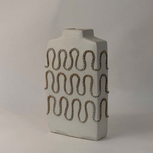 Side angle view of tall white ceramic vase with zigzag carved textured design perfect for modern shelf and living room decor.