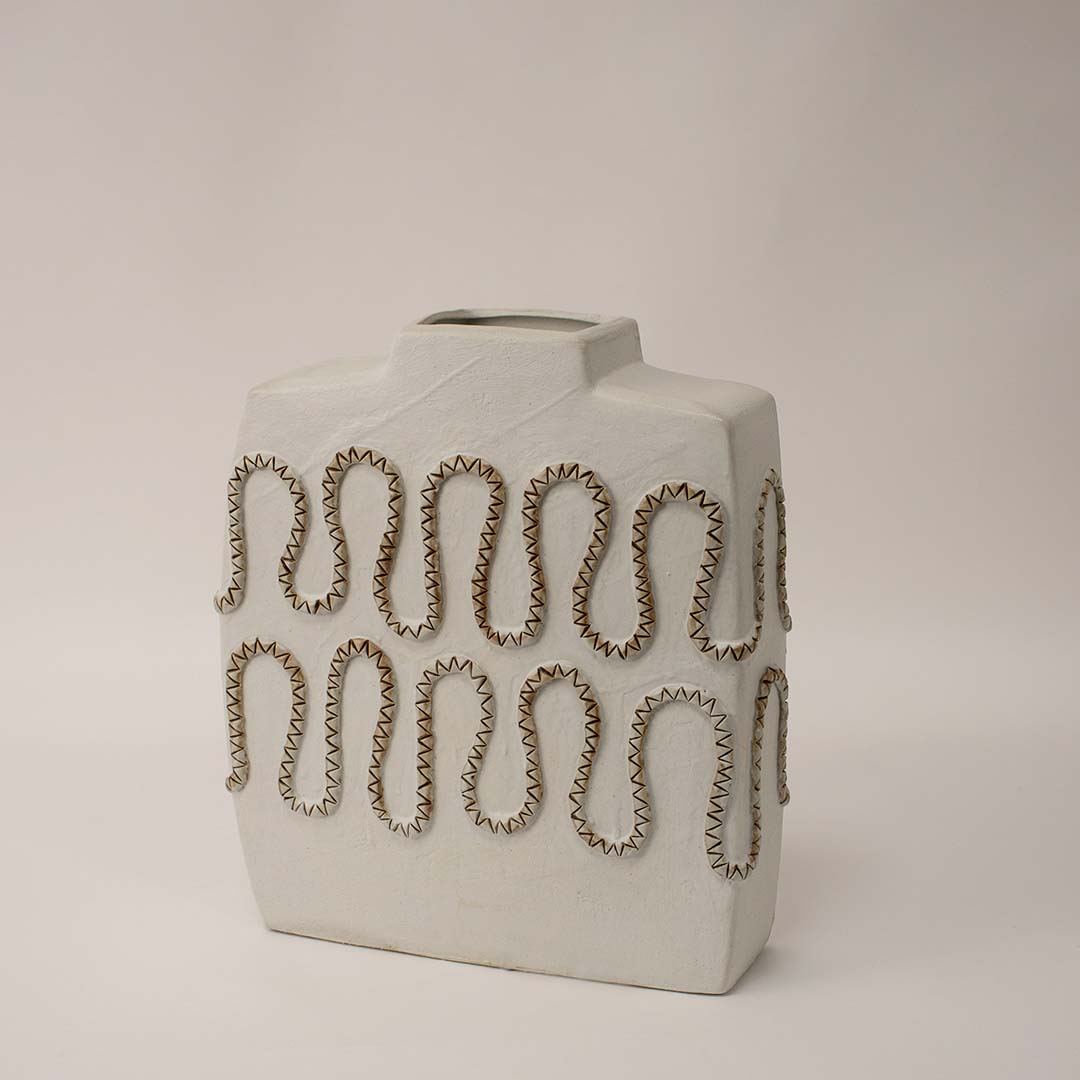 White ceramic decorative vase shown from side angle highlighting cutout pattern and sculptural profile for artistic home decor use.