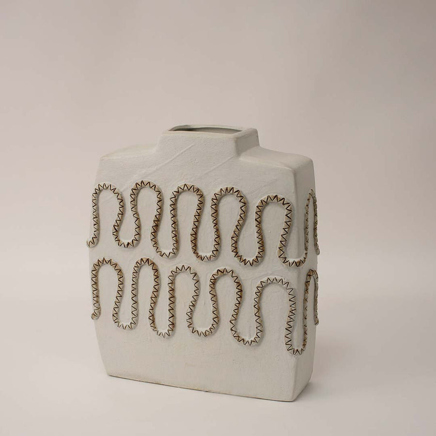 White ceramic decorative vase shown from side angle highlighting cutout pattern and sculptural profile for artistic home decor use.