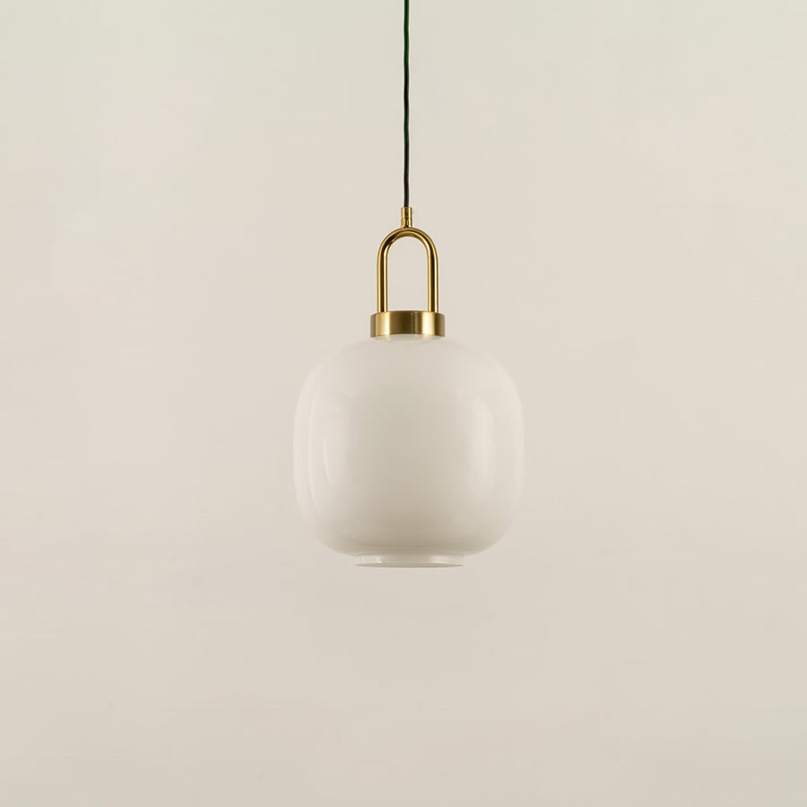 A gold and white glass pendant light with lights off on a white background highlighting its smooth rounded glass shade and refined metal accents.