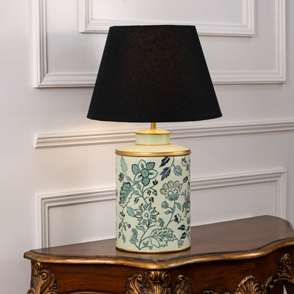 Table lamp on white background showcasing teal floral patterned ceramic base combined with an elegant black fabric lampshade.