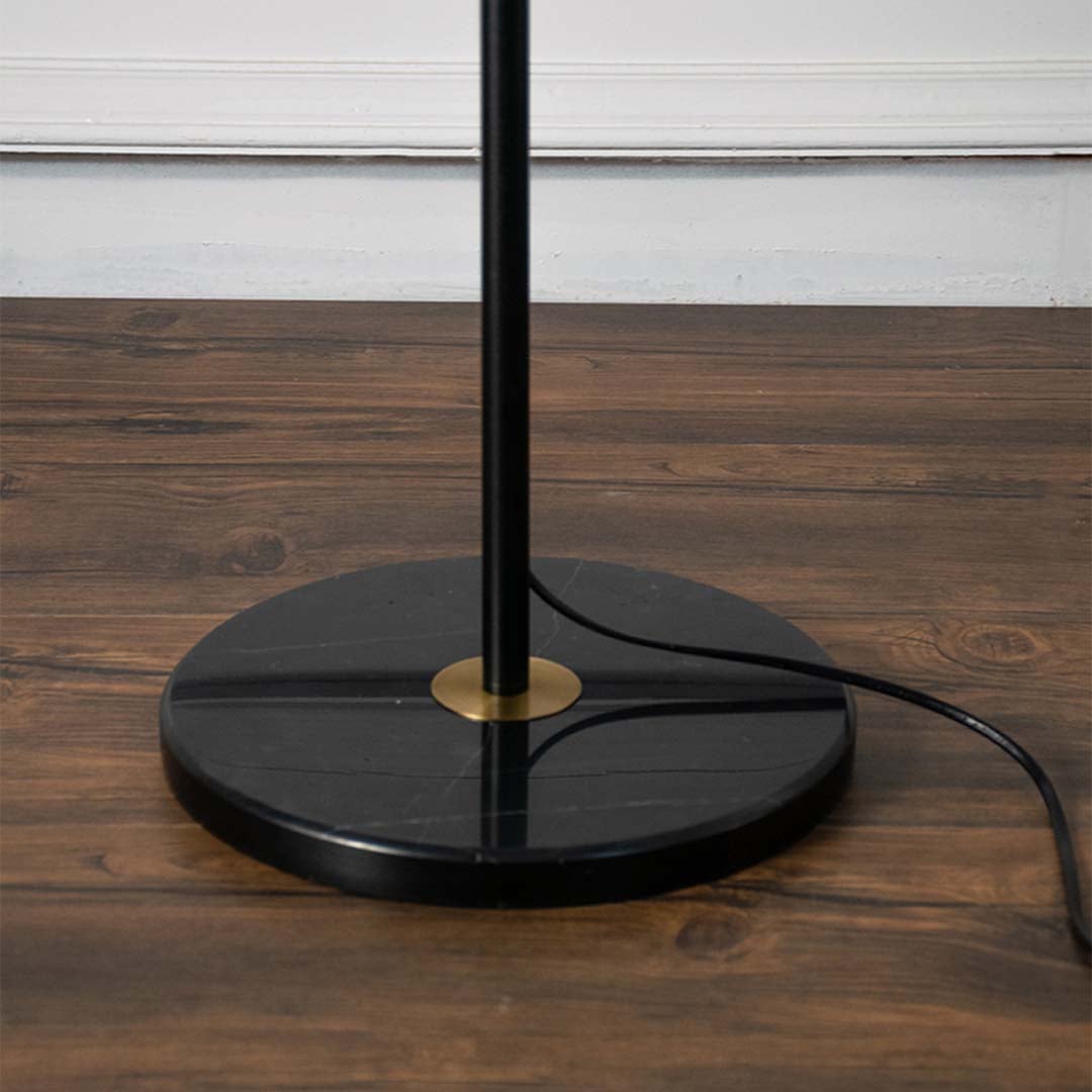 Closeup view of the floor lamp white pleated shade and black base highlighting the elegant design.