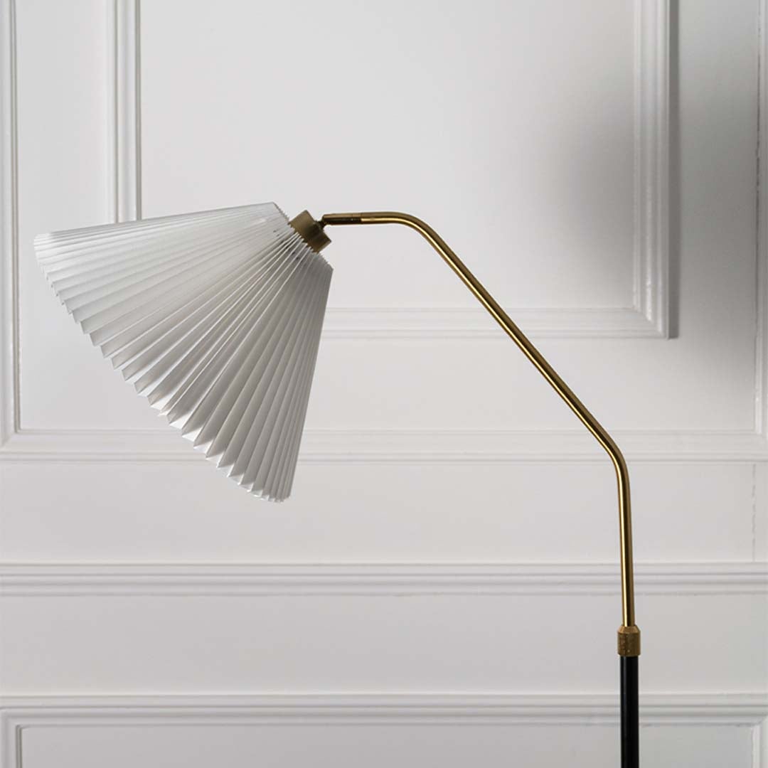 Closeup view of the floor lamp white pleated shade and black base highlighting the elegant design.