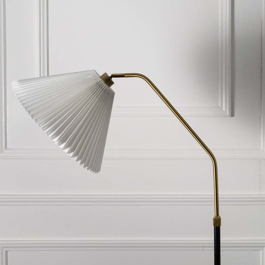 Closeup view of the floor lamp white pleated shade and black base highlighting the elegant design.