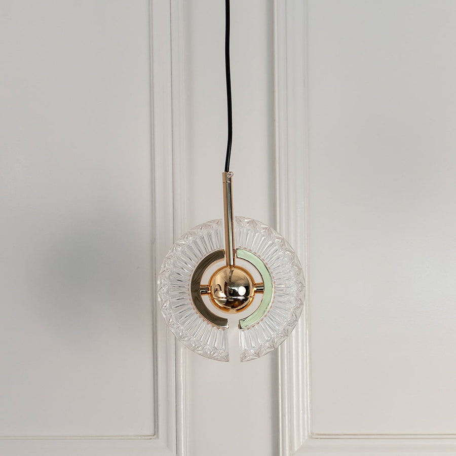 Crystal halo pendant light turned off featuring circular glass design and metallic brass detailing against white background.
