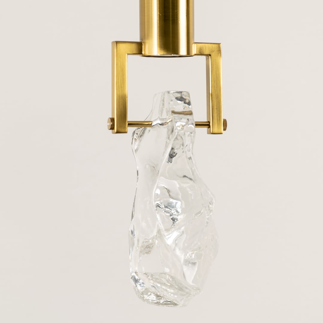 Gold metal pendant light closeup featuring crystal accent detailing and premium luxury lighting craftsmanship quality.