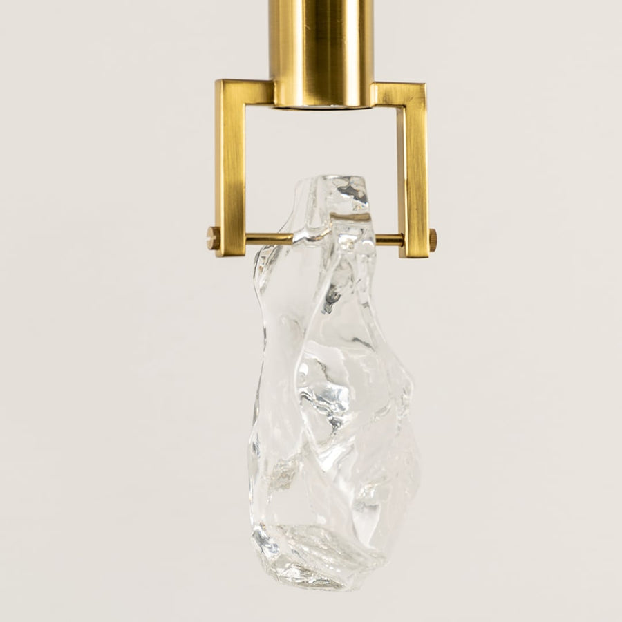 Gold metal pendant light closeup featuring crystal accent detailing and premium luxury lighting craftsmanship quality.