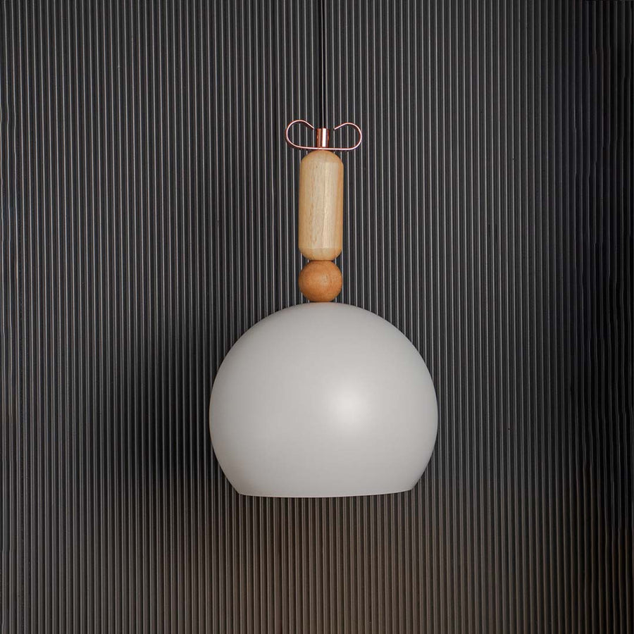 Matte white dome pendant lamp with wooden accent displayed off on black background for elegant modern interiors.