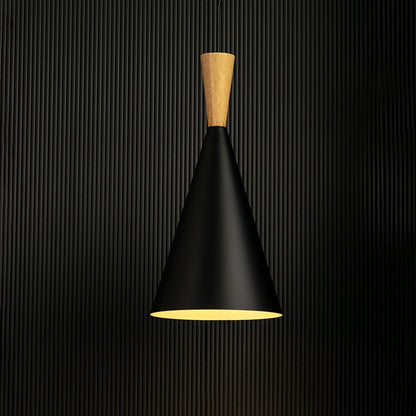 Pendant light with a black cone shade and wooden top is illuminated against a black background for contrast.