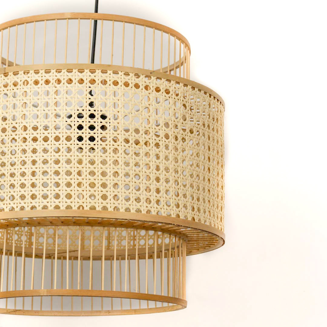 Cane pendant light with double layer drum shape and clean woven texture hanging against soft neutral wall background for contemporary decor styling.