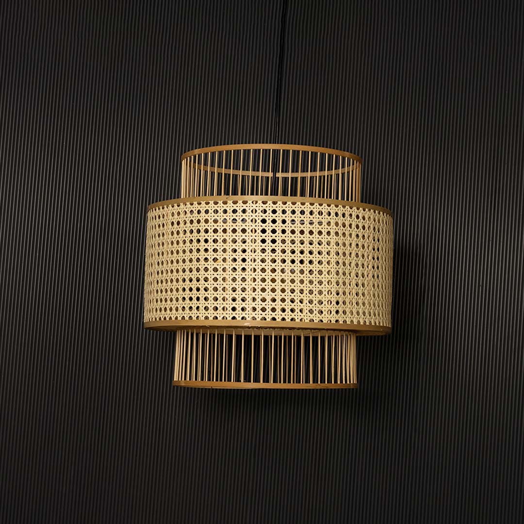 Natural rattan pendant light displayed off on black background showing elegant handcrafted layered design.